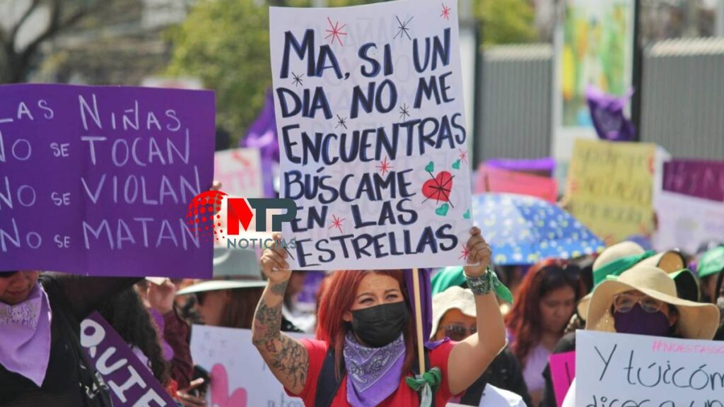 Mujer marcha en Puebla en el 8M 2023, levantando un cartel con la frase "Ma, si un día no me encuentras búscame e las estrellas."