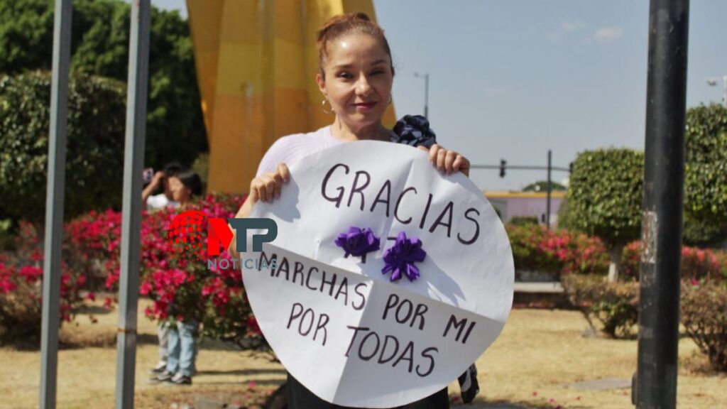 Mujer apoya marcha 8M a su paso por el bulevar 5 de Mayo en Puebla.