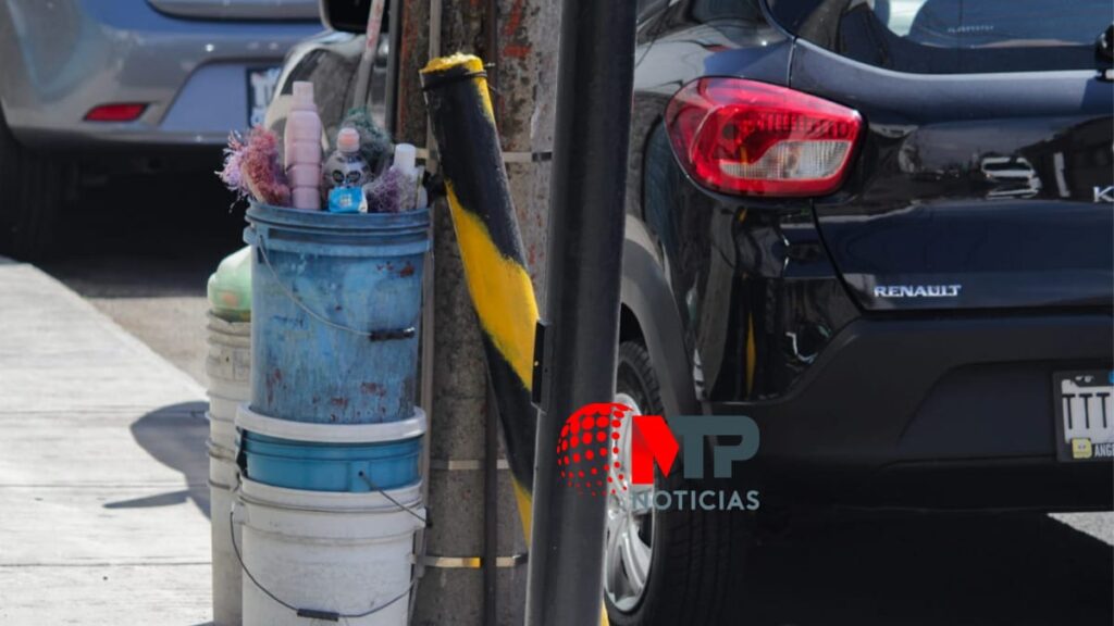 Botes y rejas apartando lugar en calles de Puebla