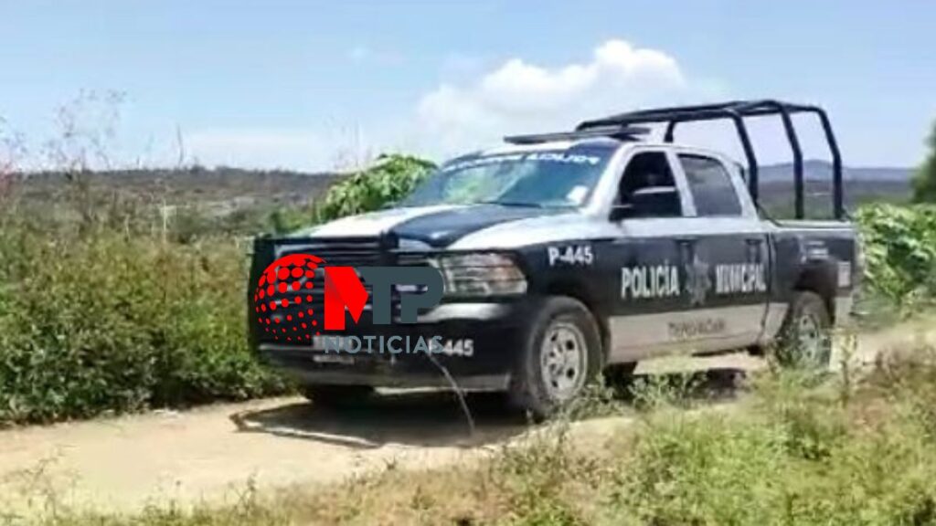 Policía municipal de Tehuacán estacionada cerca de canal de riego.