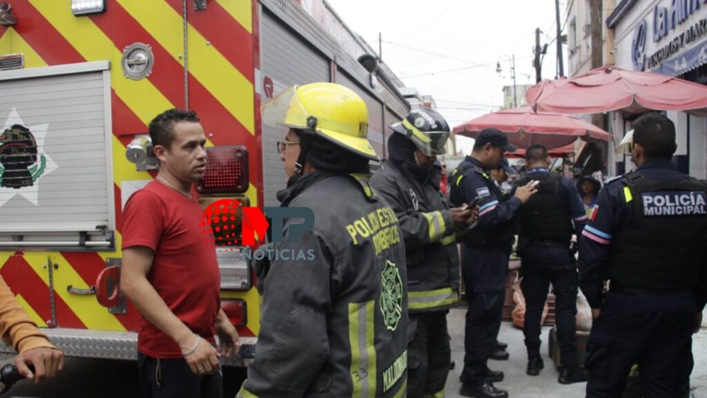 Bomberos hablan con ciudadanos en marisquería del centro de Puebla.