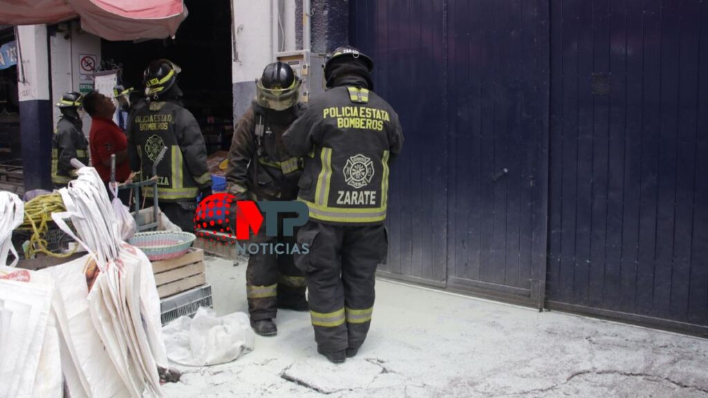 Bomberos revisan local en centro de Puebla tras incendio.