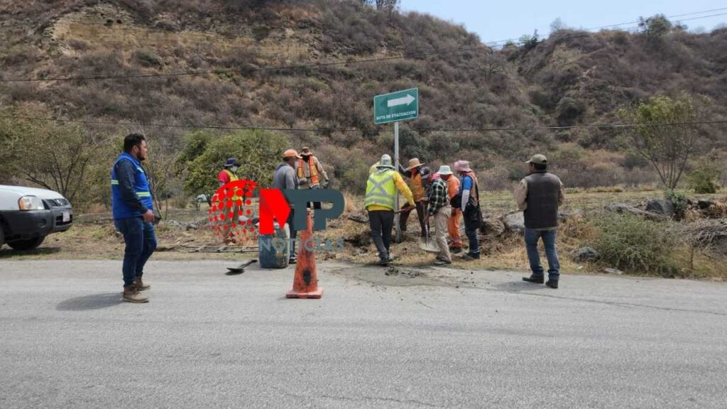 Trabajadores colocando señalética en ruta de evacuación ante erupción del volcán Popocatépetl.