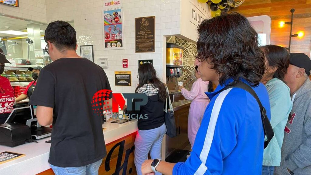 Clientes de Carl's Jr. formados frente al mostrador en Puebla.