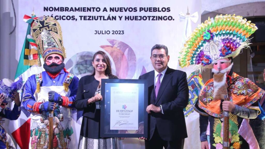 Angélica Alvarado y el gobernador Sergio Salomón Céspedes con el título de nombramiento de Pueblo Mágico.