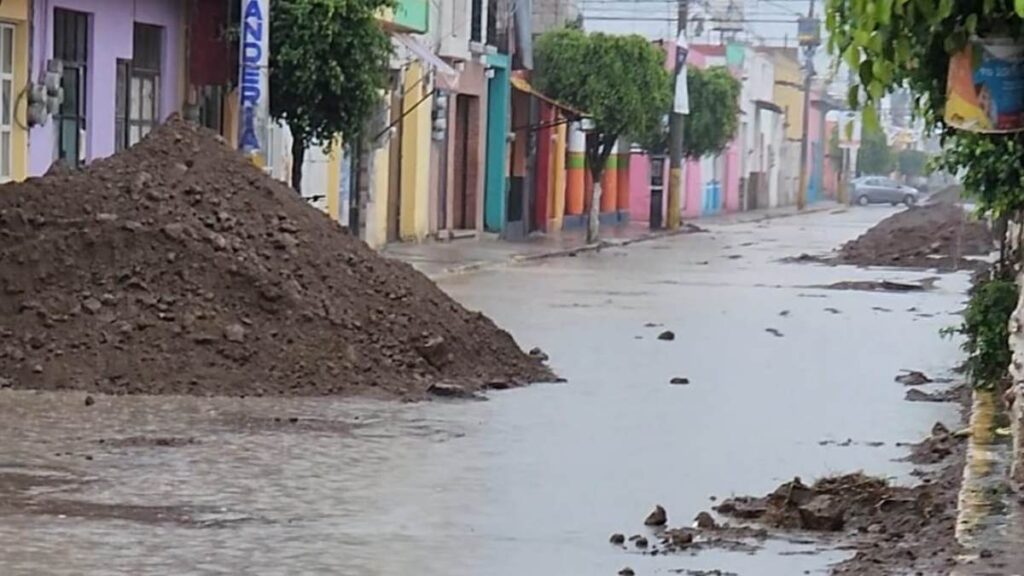 Calle 16 de septiembre en San Andrés Cholula, Puebla, con montículos de tierra y lodo tras caída de lluvia.