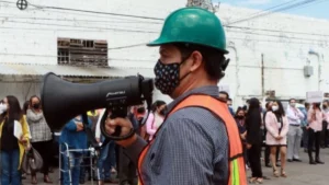 Trabajador de Protección Civil con megáfono en mano durante simulacro en Puebla.