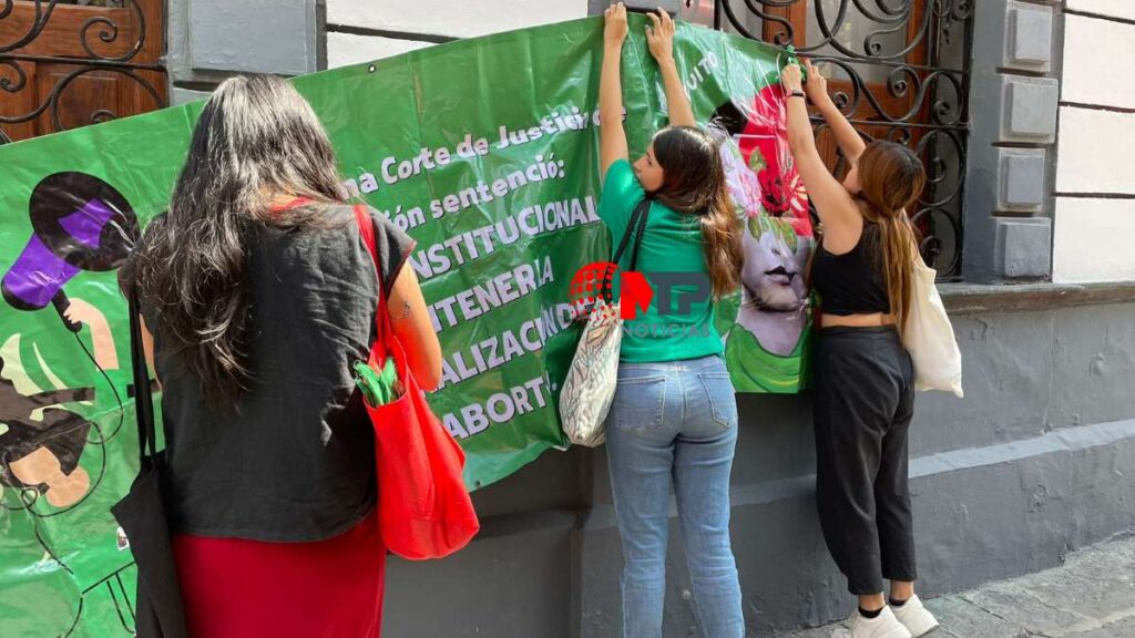 Colectivas feministas colocan lona en fachada del Congreso de Puebla para despenalizar el aborto.