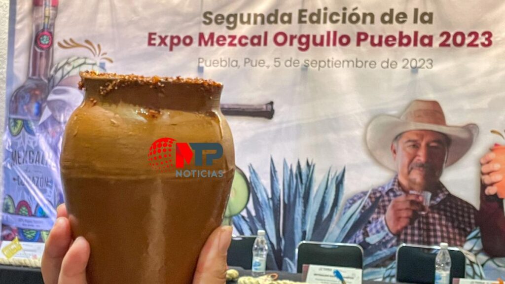 Cantarito y de fondo cartel de Expo Mezcal Orgullo Poblano 2023.