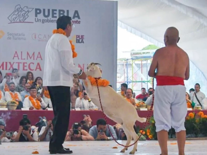 Gobernador Sergio Salomón bailando con un chivo en el ritual de matanza