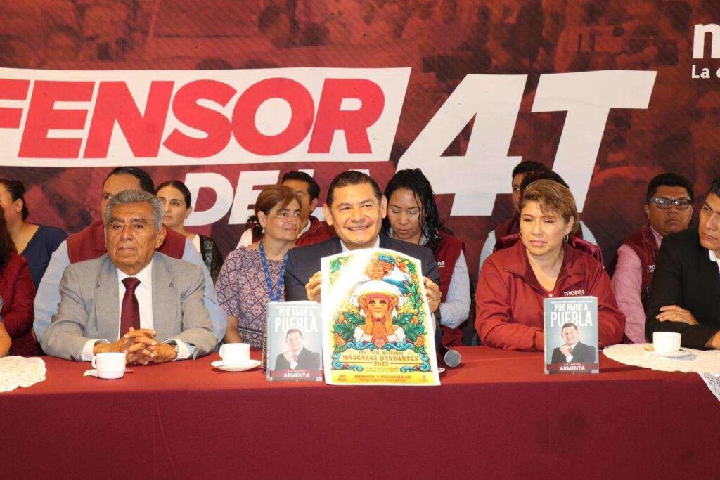 Alejandro Armenta en rueda de prensa muestra un cartel del Festival Nacional Máscara Danzantes.
