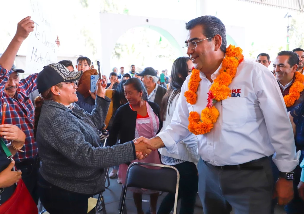 El gobernador de Puebla, platicando con una mujer en el municipio de Domingo Arenas