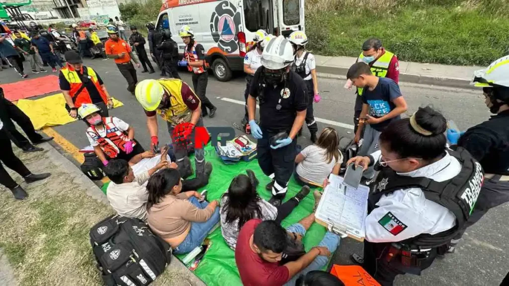 Paramédicos y personal de Protección Civil revisan a pasajeros de transporte público tras choque.