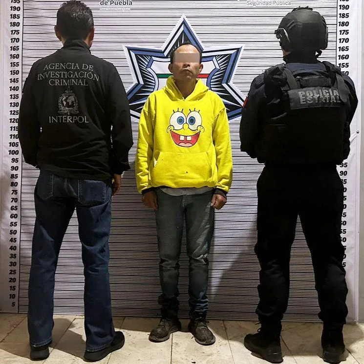 Policía de Puebla, personal de la Interpol y hombre detenido en Puebla.