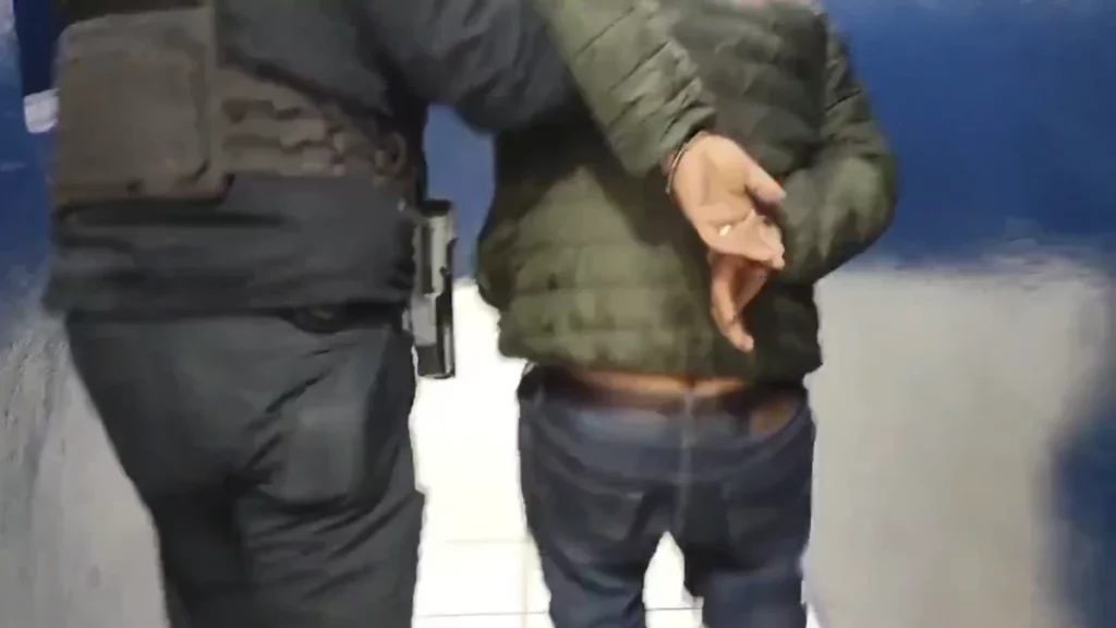Policía de Puebla capital lleva a presunto ladrón esposado.
