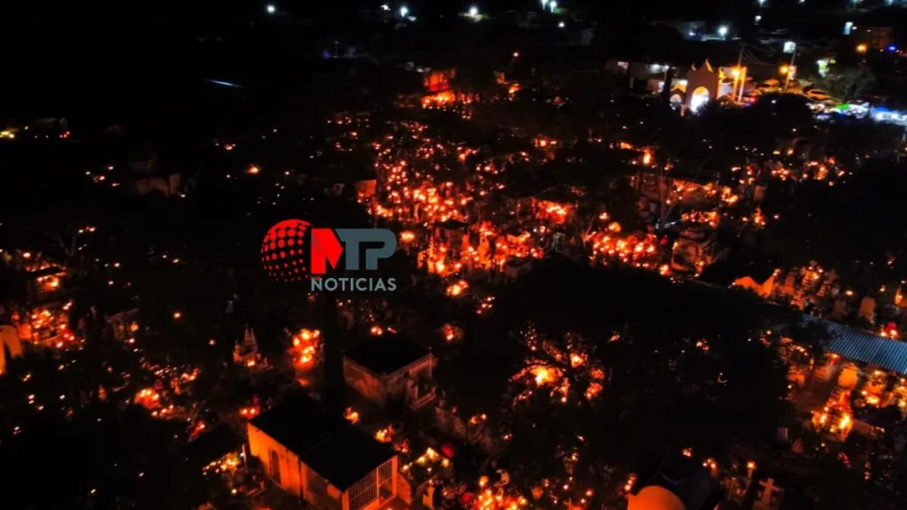Tumbas en panteón iluminadas con velas por quema de cera en la Mixteca.