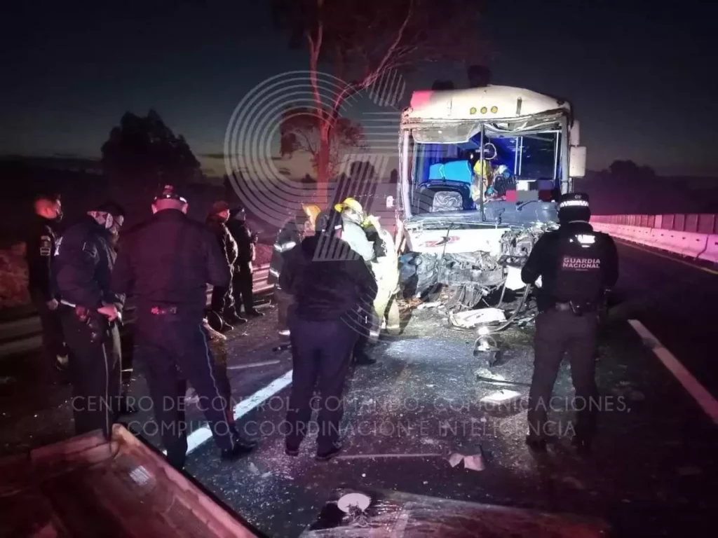 Autobús que chocó y personal de emergencias que atendió a lesionados.