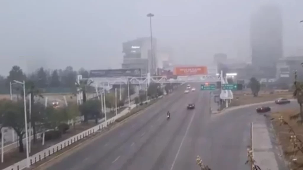 Autos circulando en la Vía Atlixcáyotl entre densa niebla.