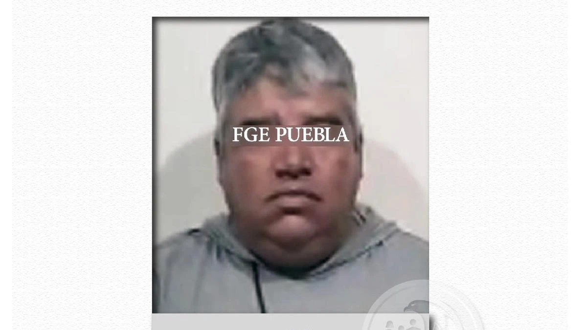 Hombre con suéter gris y el rostro tapado, luego de ser detenido
