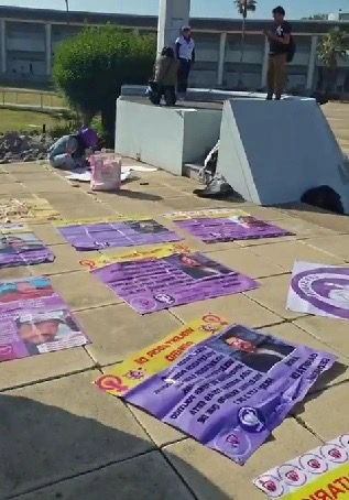 Carteles en el suelo durante protesta de Frente Poblano de Mujeres Contra Deudores Alimentarios