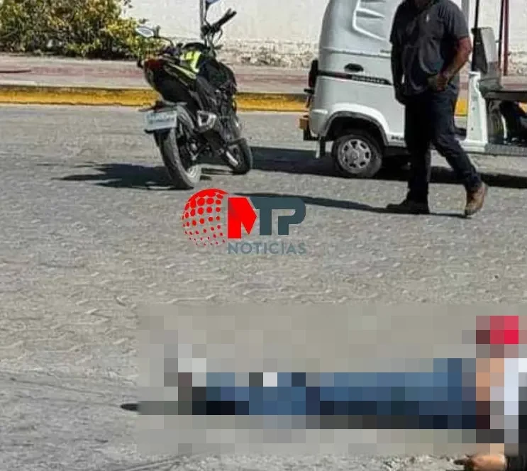 Mototaxi, moto y hombre caminando en la calle tras balacera en Acatzingo, un cadáver en el suelo.