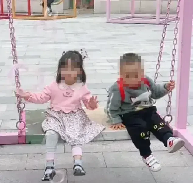 Niños menores de dos años sentados en un columpio.