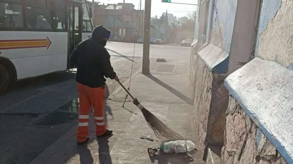 Trabajadores de Organismo Limpia barriendo calle en la ciudad de Puebla.