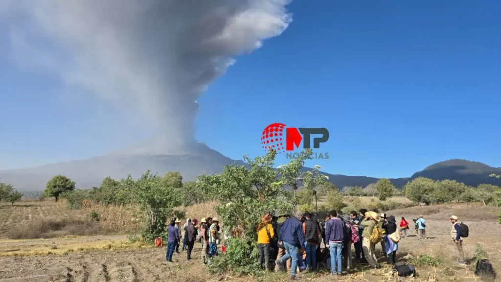Volcá Popocatépetl lanzando fumarola y pobladores que lo festejan mediante una ceremonia en Puebla.