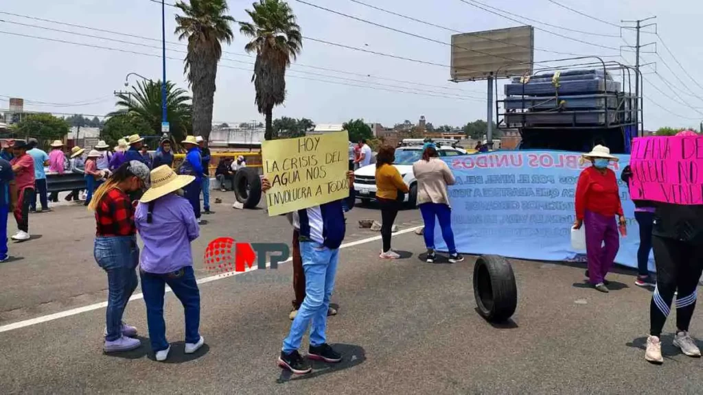 Pobladores de Xoxtla protestan con pancartas en la autopista México-Puebla.