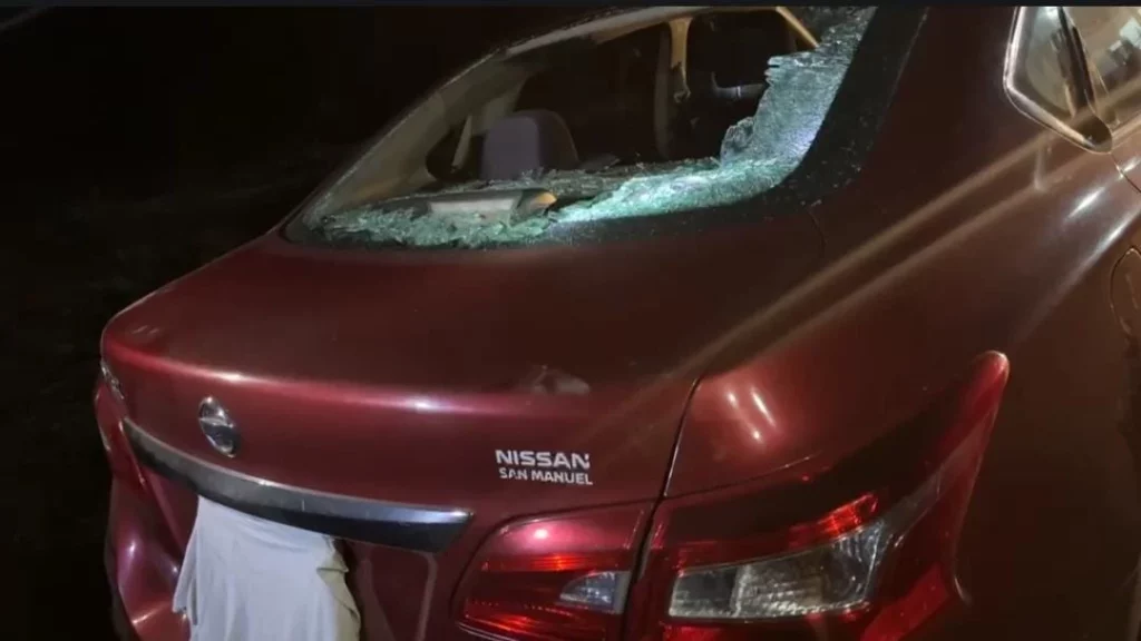 Auto con cristales rotos, presuntamente por policías municipales en bloqueo de relleno sanitario de Cholula.