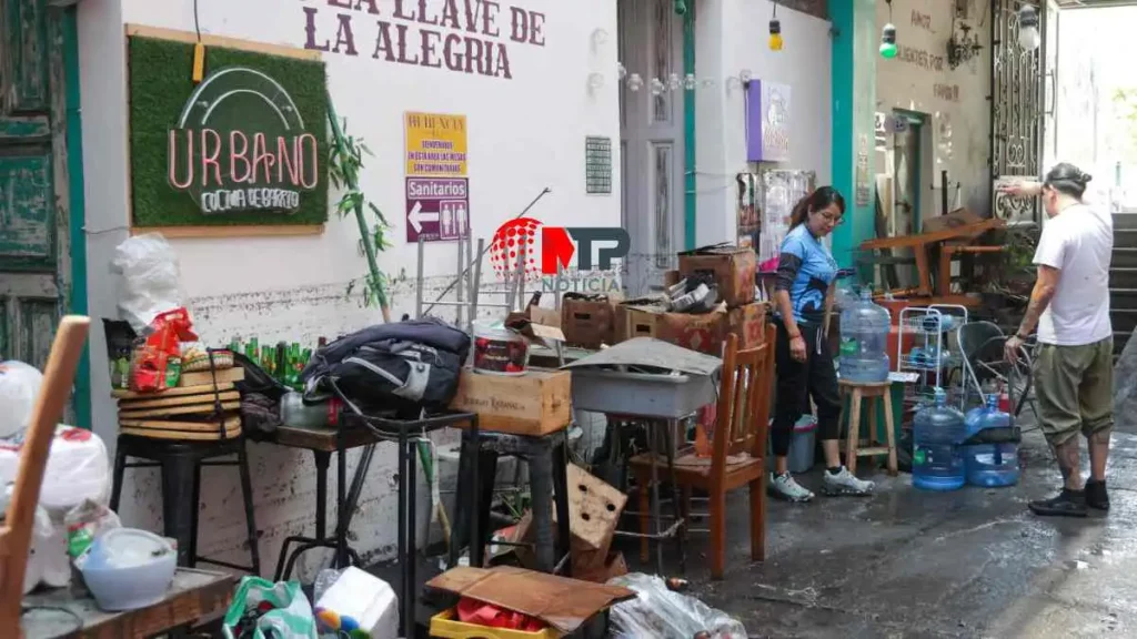 Locatarios de plaza La Herencia limpian negocios dañados por lluvias.