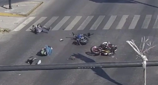 Personas en el suelo tras choque de motos en carretera.