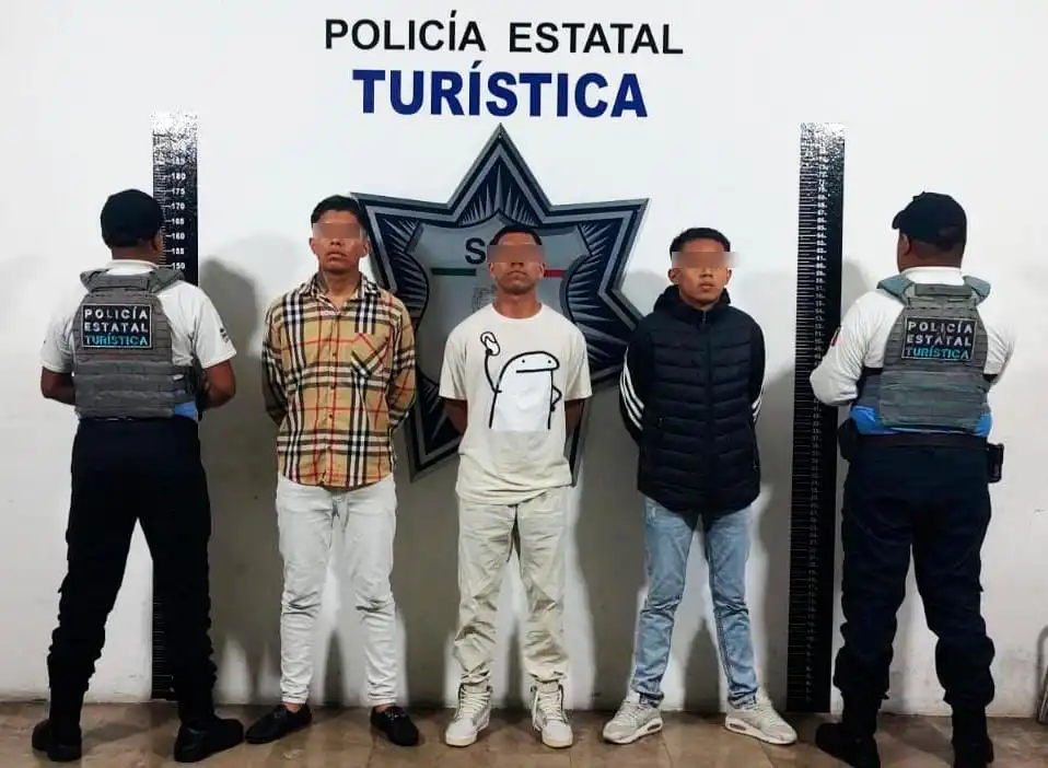 Tres hombres custodiados por dos policías de Puebla.