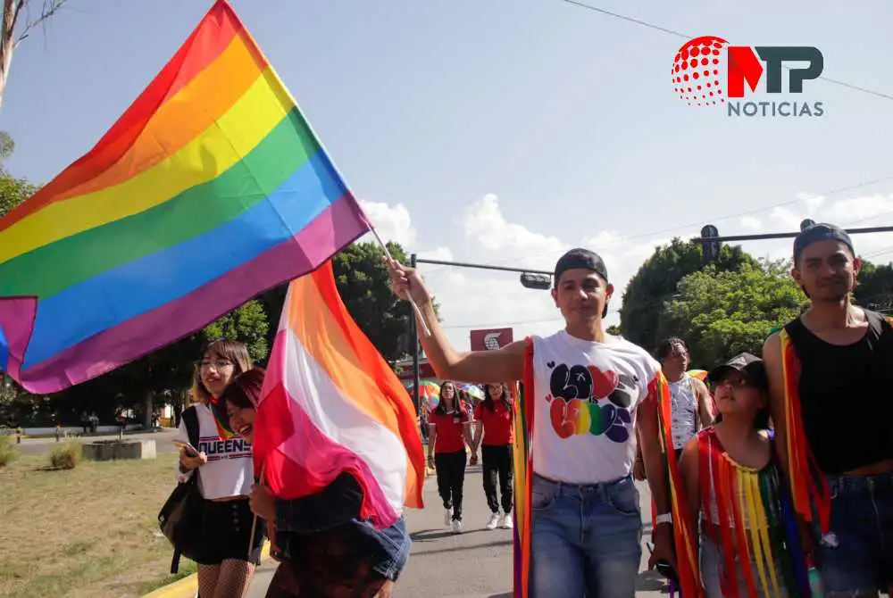 Miembro de la comunidad LGBTTTIQ muestra bandera durante marcha en ciudad de Puebla.