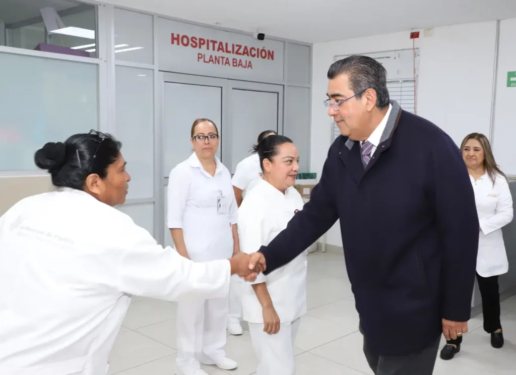 Sergio Salomón saluda a enfermera de hospital IMSS-Bienestar en Puebla.