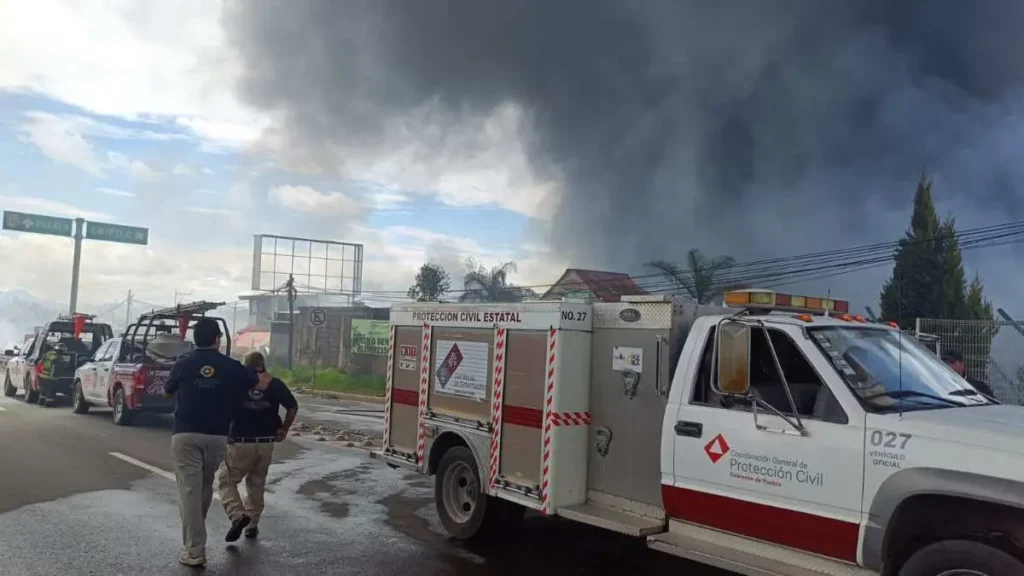 Camioneta de Protección civil Estatal de Puebla cerca de maderería incendiada.