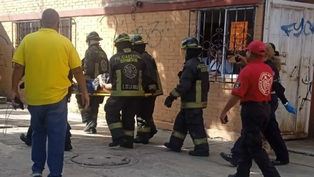 Bomberos trasladan en camilla a hombre electrocutado en Puebla.