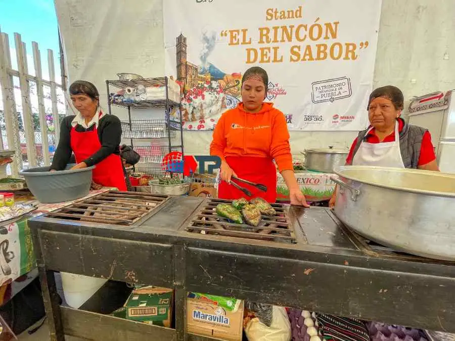 La señora Minerva (a la izquierda) junto a otras dos mujeres que la ayudan a preparar sus Chiles en Nogada.