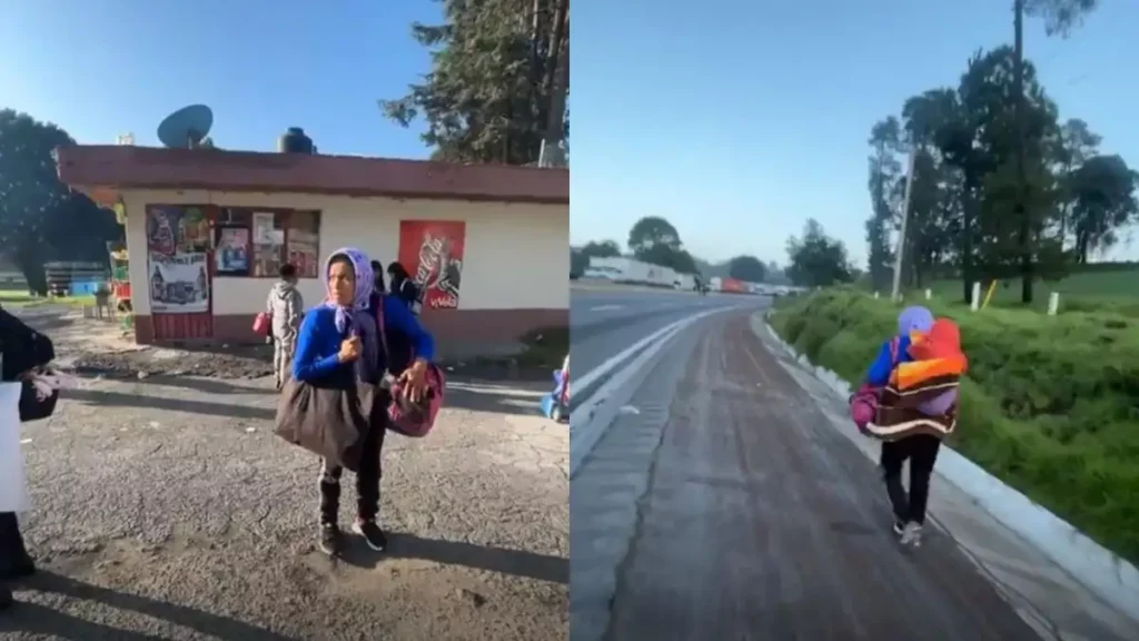 Mujer camina en carretera cargando con rebozo a su hijo ante bloqueo vial.