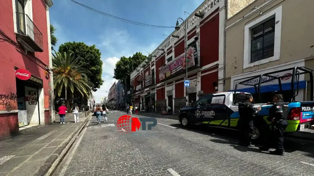 Calle 10 Poniente en Centro Histórico de Puebla, patrullas estacionadas para evitar instalación de amulantes.