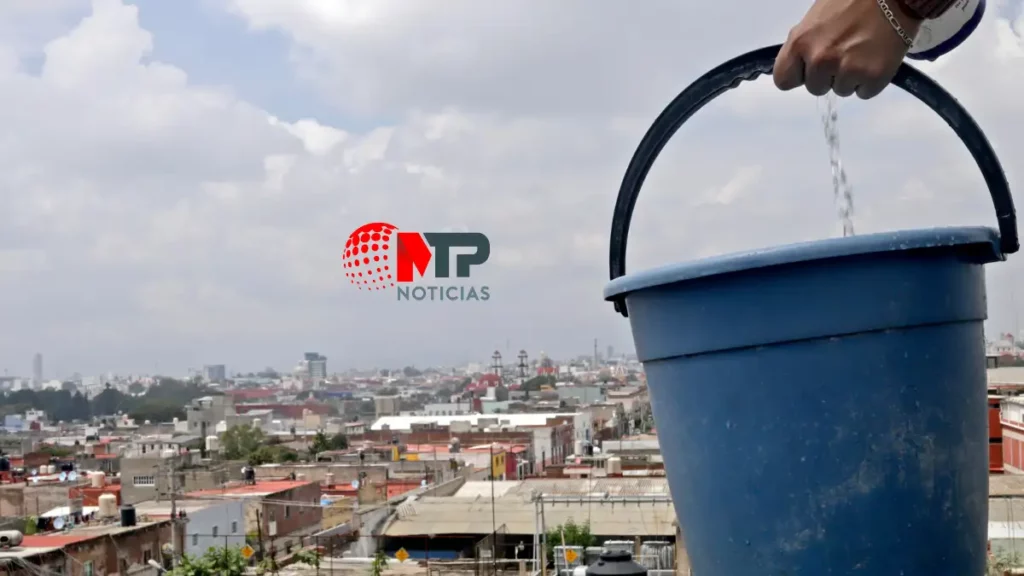 Una mano agarrando una cubeta con agua potable.