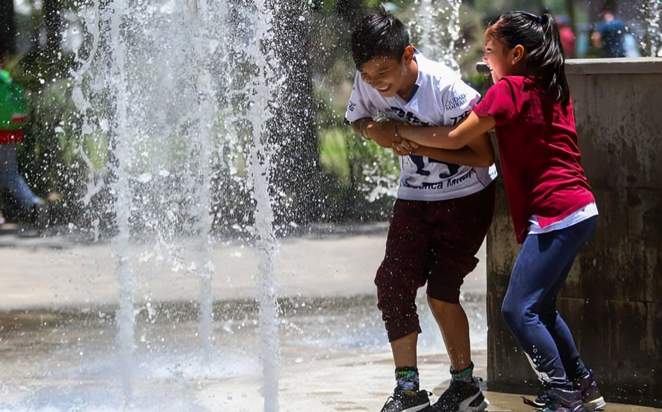 Hermanos jugando en una fuente