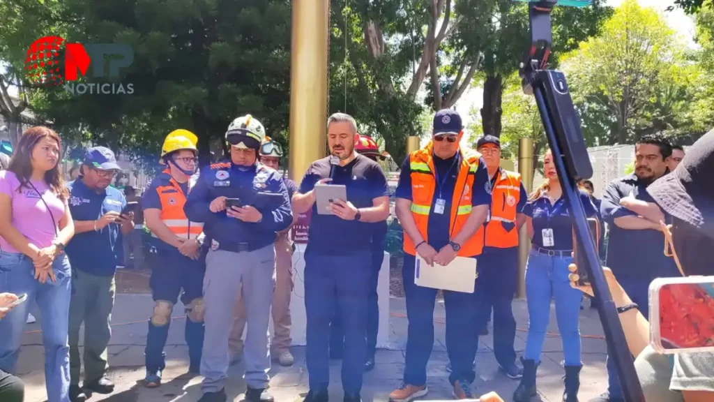 Adán Domínguez y elemento de Protección Civil en el Zócalo de Puebla.